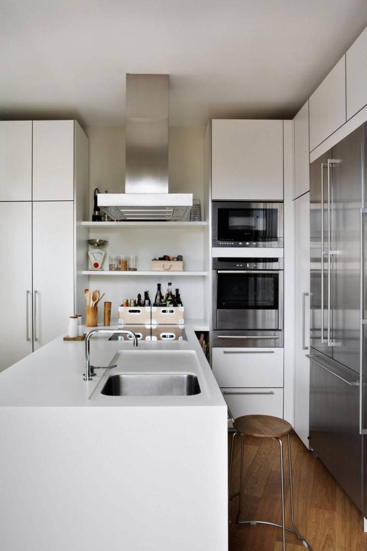 20 - Alluring contemporary penthouse kitchen rectangle shape white kitchen island composite kitchen sink white kitchen cabinets built in oven built in fridge built in stoves stainless steel cooker hood