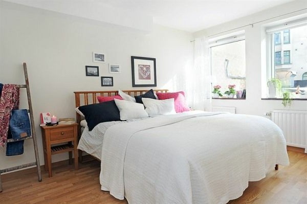 Designed bedrooms in a Scandinavian style full size bed with plenty of boxes of white walls wooden staircase for clothes