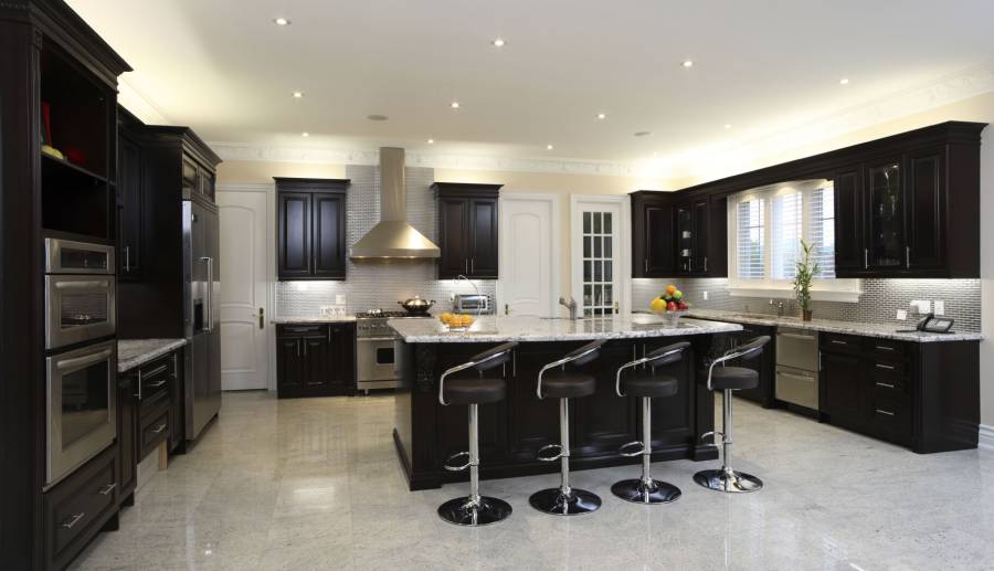 Contemporary kitchen with dark wood cabinets and white marble counters