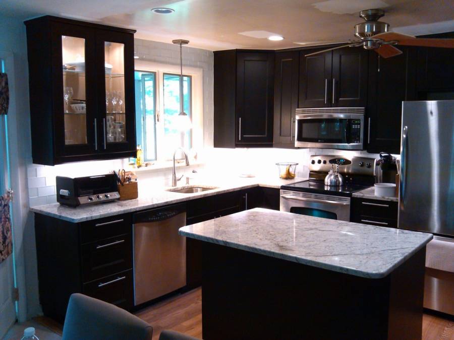 Contemporary kitchen with dark wood cabinets and white marble counters