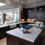 Contemporary kitchen with dark wood cabinets and white marble counters