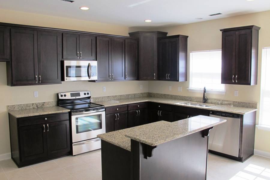 Contemporary kitchen with dark wood cabinets and white marble counters