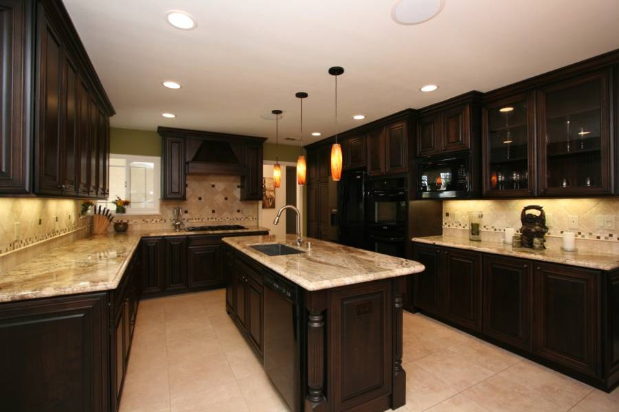 Contemporary kitchen with dark wood cabinets and white marble counters