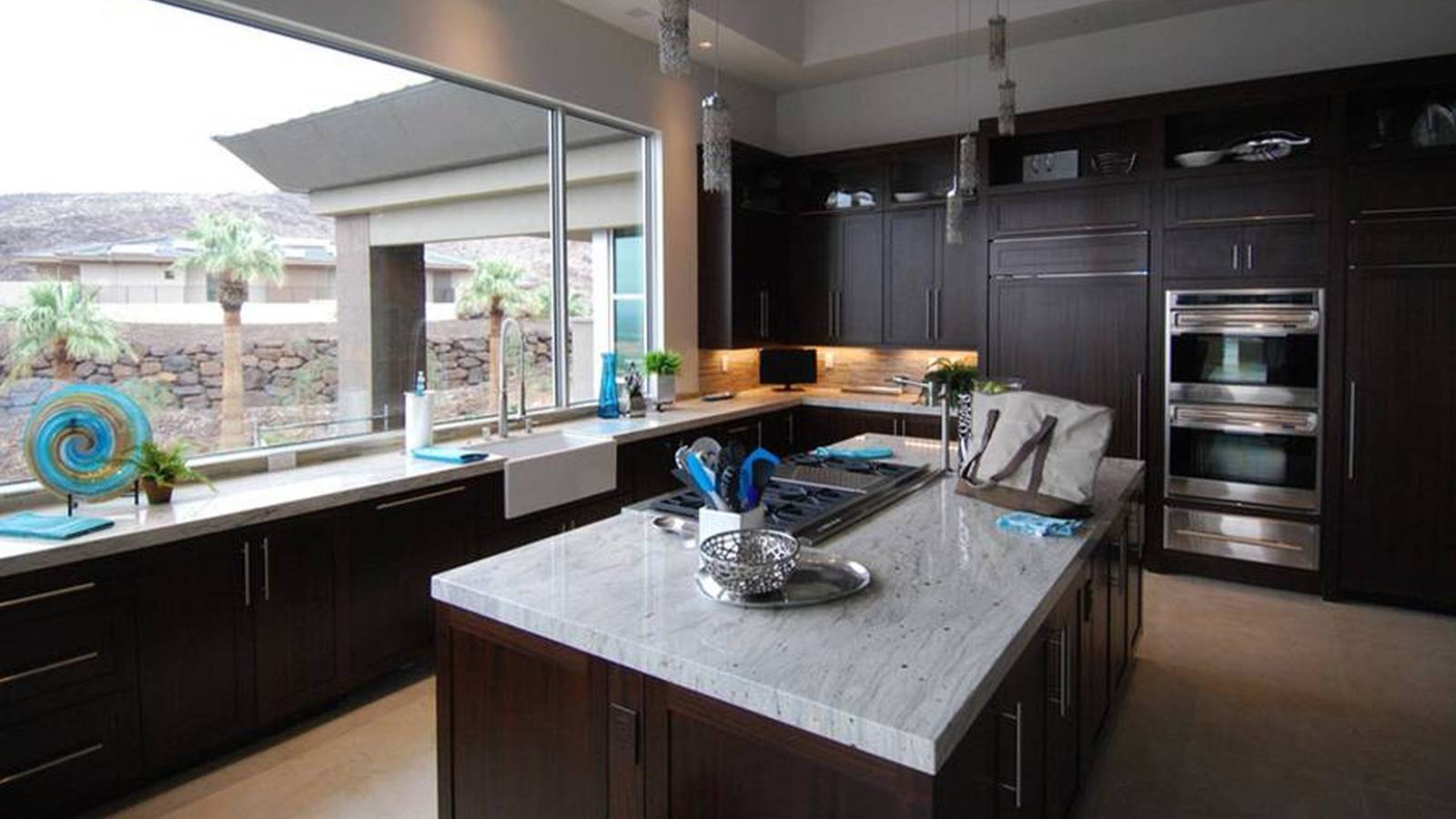 Contemporary kitchen with dark wood cabinets and white marble counters