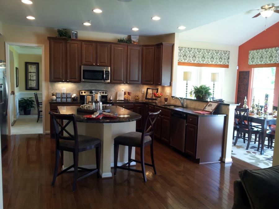 Contemporary kitchen with high ceilings light wood floors and dark cabinets