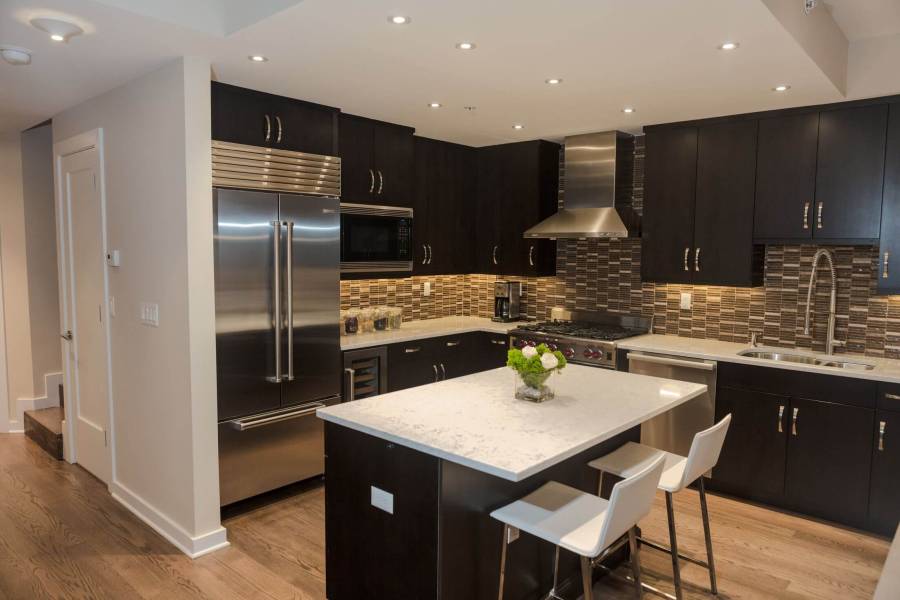 Contemporary kitchen with high ceilings light wood floors and dark cabinets