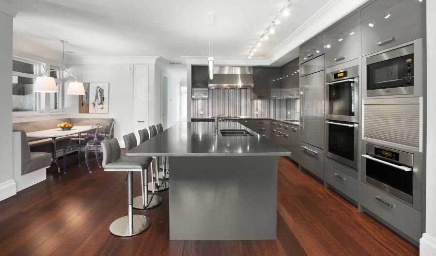 Contemporary kitchen with high ceilings light wood floors and dark cabinets