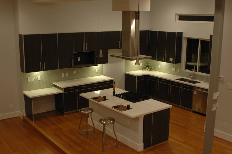 Contemporary kitchen with high ceilings light wood floors and dark cabinets