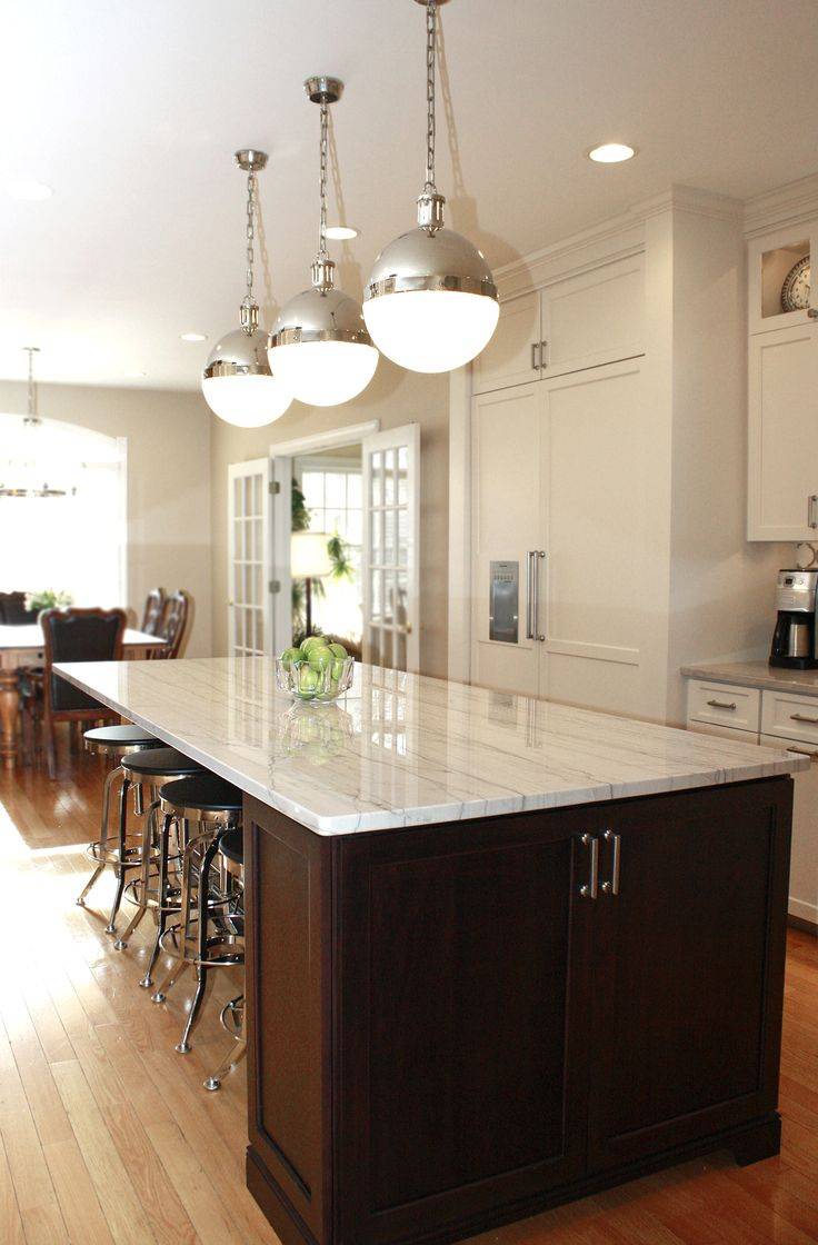 Contemporary kitchen with light granite counters dark wood island