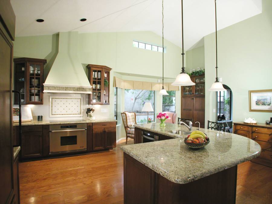 Contemporary kitchen with light granite counters dark wood island