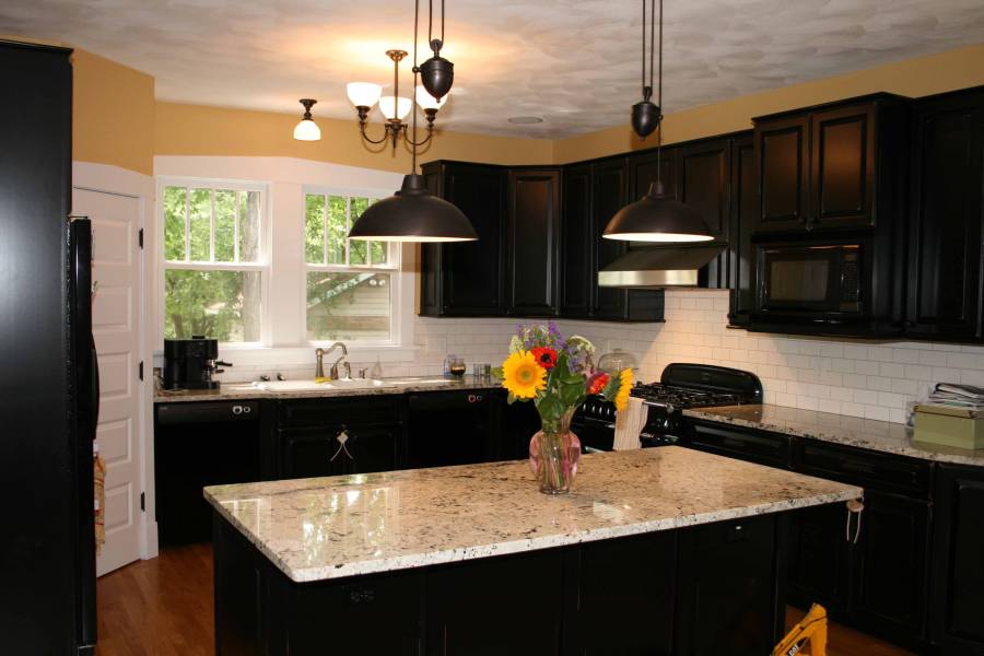 Contemporary kitchen with light granite counters dark wood island