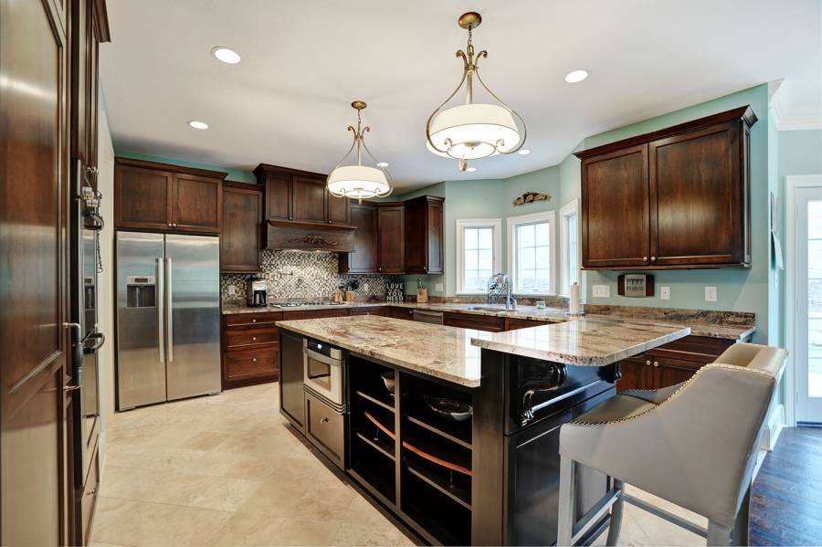 Contemporary kitchen with light granite counters dark wood island