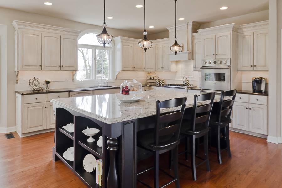 Contemporary kitchen with light granite counters dark wood island