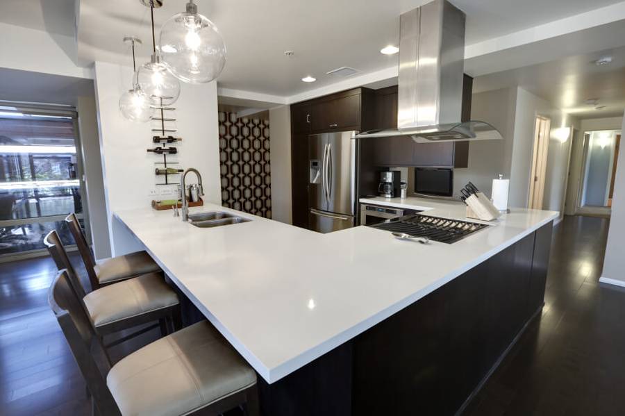 Designer custom kitchen with concrete counter island with dining nook