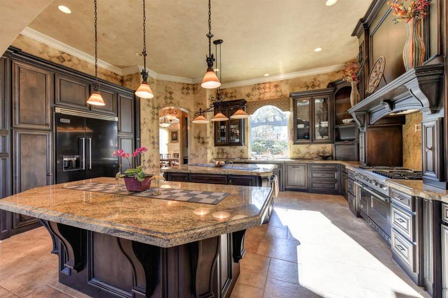 Kitchen with beige granite counters travertine tile floor and rich wood cabinets