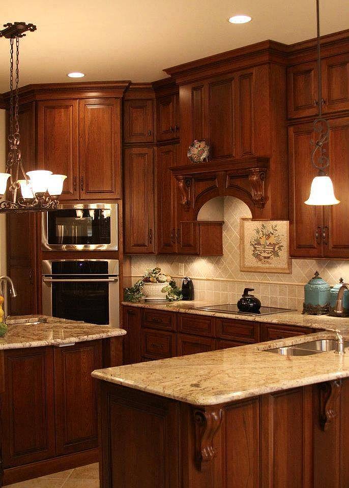 Kitchen with beige granite counters travertine tile floor and rich wood cabinets