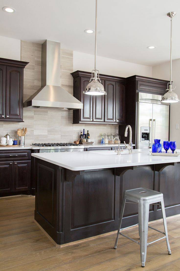 Kitchen with open layout, limestone flooring and dark cabinetry