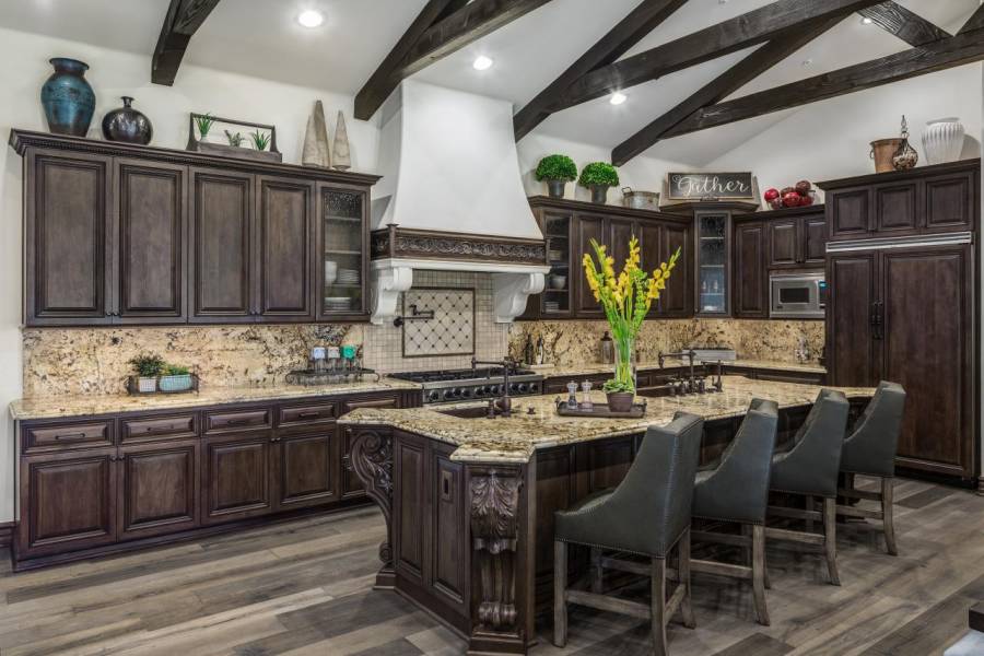 Kitchen with open layout, limestone flooring and dark cabinetry