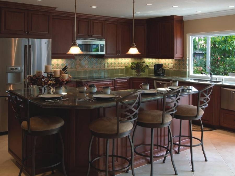 Kitchen with open layout, limestone flooring and dark cabinetry