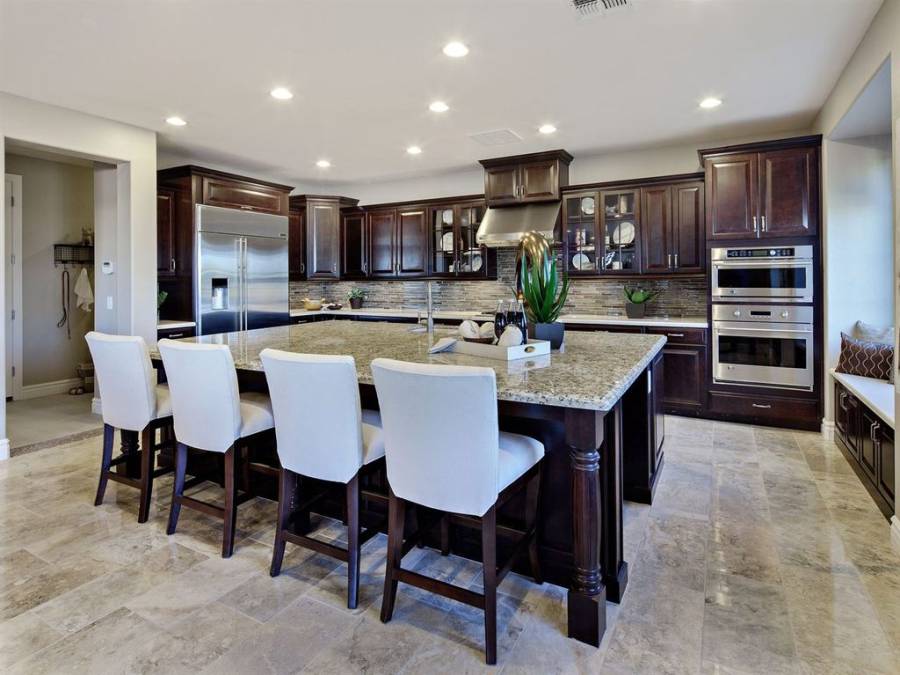 Kitchen with open layout, limestone flooring and dark cabinetry