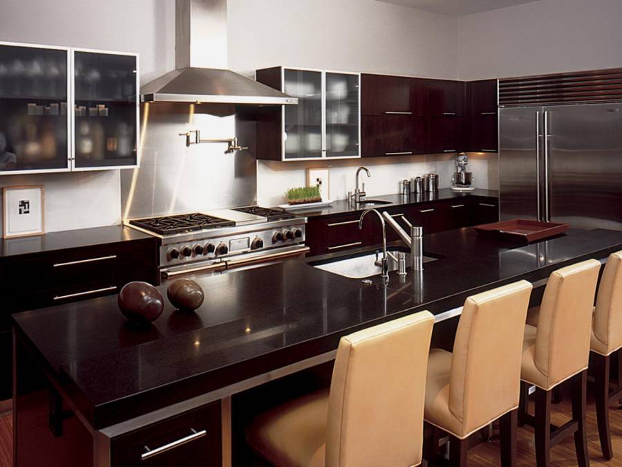 Kitchen with open layout, limestone flooring and dark cabinetry