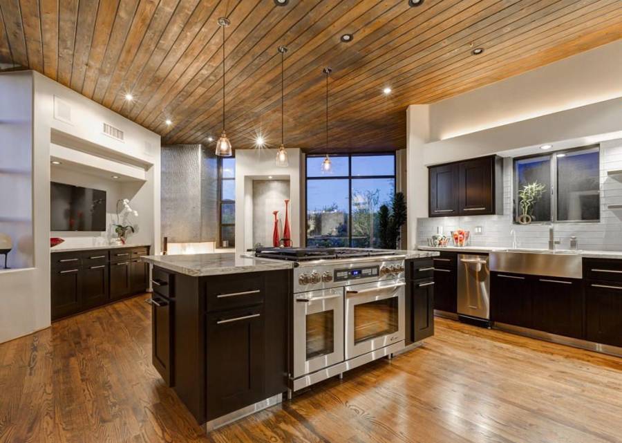 Kitchen with open layout, limestone flooring and dark cabinetry