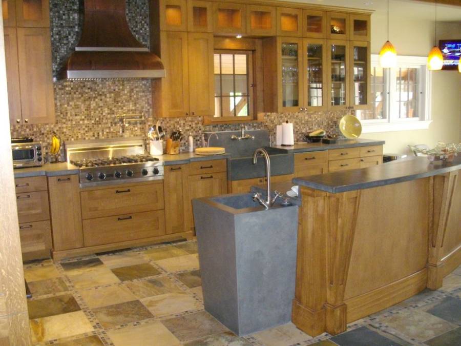 Kitchen with open layout, limestone flooring and dark cabinetry