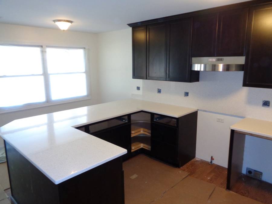 White quartz counter kitchen with dark wood