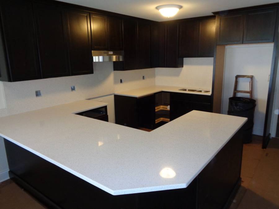 White quartz counter kitchen with dark wood