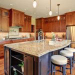 Contemporary kitchen with light granite counters dark wood island