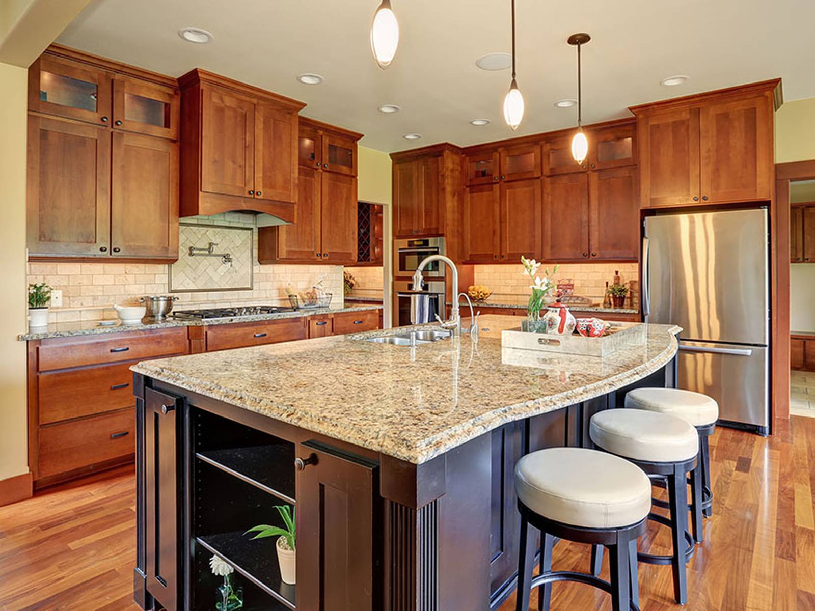 Contemporary kitchen with light granite counters dark wood island