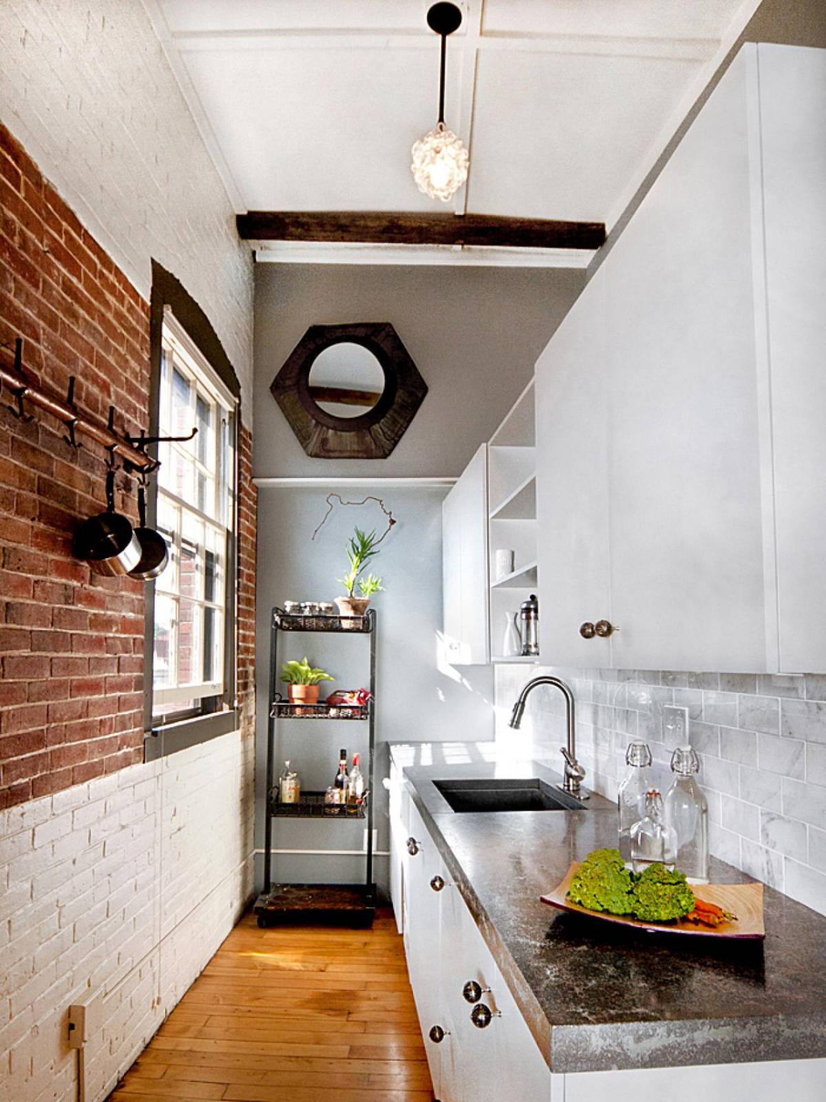 Great design of modern and small loft kitchen with bricks wall and galley style layout